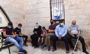 Palestinians wait to receive a Covid-19 booster vaccine in East Jerusalem.