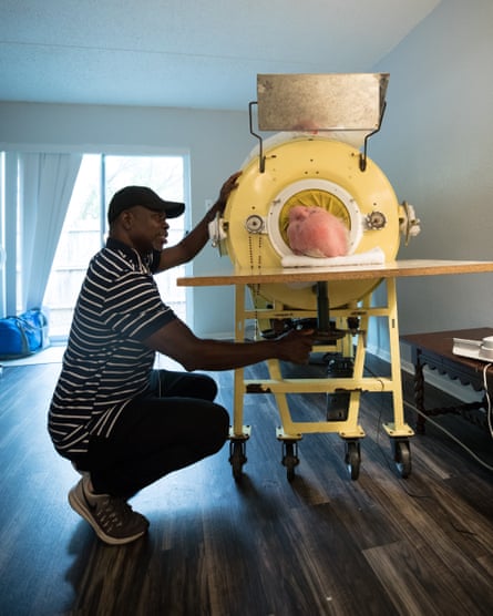 A caregiver adjusts Paul’s head rest as he lies in an iron lung in his apartment in Dallas, Texas.