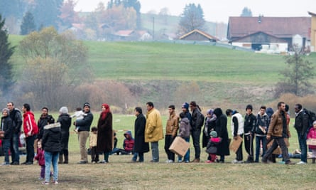 Refugees heading for Germany queue in an Autrian field.