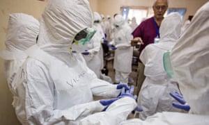 A World Health Organization, WHO, worker,  right rear, trains nurses to use Ebola protective gear in Freetown, Sierra Leone, Thursday,  Sept. 18, 2014. Shoppers crowded streets and markets in Sierra Leone's capital on Thursday stocking up for a three-day shutdown that authorities will hope will slow the spread of the Ebola outbreak that is accelerating across West Africa. (AP Photo/Michael Duff)