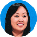 woman smiling and looking to side with blue background