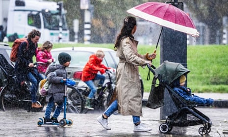 People brave wind and rain in Rotterdam in the Netherlands.