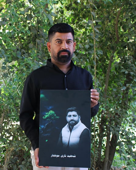 A man holds a large photo of his brother.