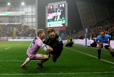 Northampton's George Hendy dives to score a try as a Gloucester player attempts a tackle
