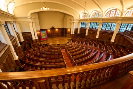 Curving rows of wooden pews seen from above.