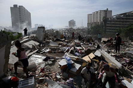 People walk amid rubble after the twin earthquake in Caraballeda, La Guaira state, about 40km northeast of Caracas.