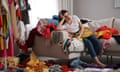 Upset young woman with lots of clothes on sofa in room