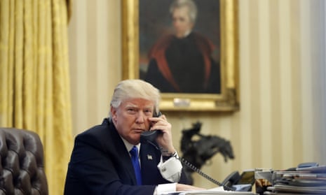 Donald Trump speaks on the telephone in the Oval Office, a portrait of Andrew Jackson behind him.