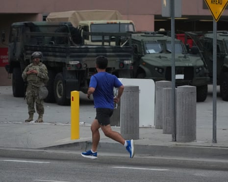 A jogger passes by as California Guards guard the Federal Building in downtown LA.