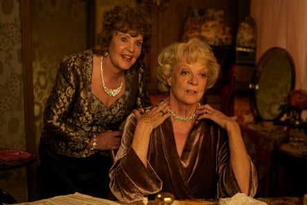 Pauline Collins with Maggie Smith facing a mirror wearing evening wear and jewels