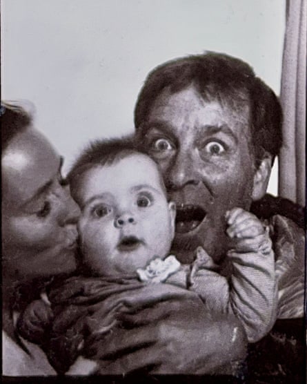 Dougald and Emma holding Madeleine between them, with a surprised look on her face