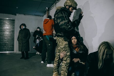 An image of love … a soldier comforts a woman in an underground car park in Kyiv.
