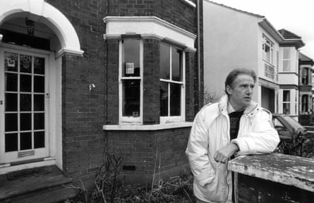 Black and white photo of Paul Brown standing outside a house