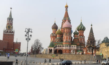 A car passes by the Kremlin and the Cathedral of Intercession of the Blessed Virgin Mary. Kremlin in Moscow, Russia.