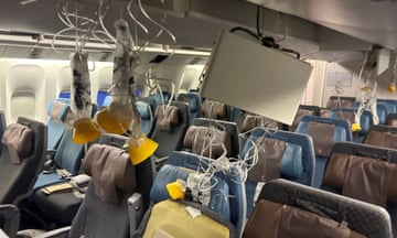 A plane cabin in disarray with oxygen masks hanging down
