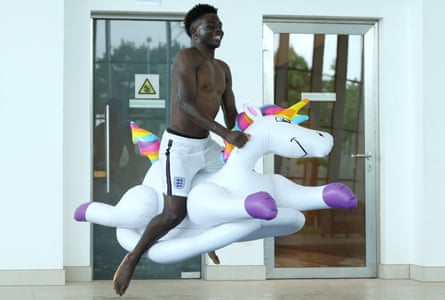 Bukayo Saka of England jumps into the swimming pool on an inflatable unicorn at St George’s Park on July 04, 2021 in Burton upon Trent, England