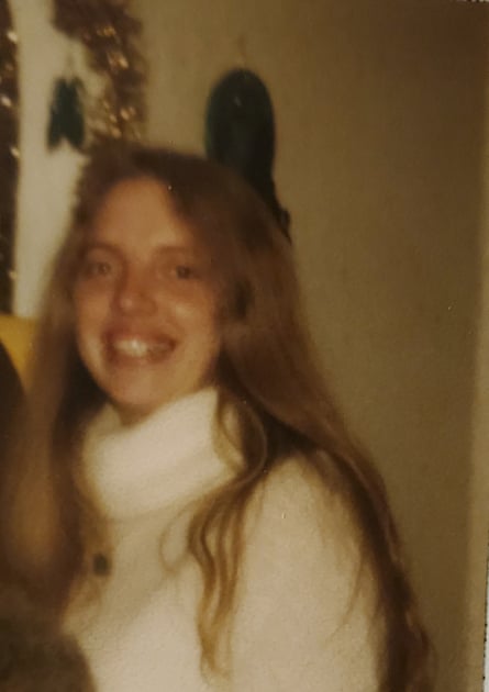 Blurry photo of a young woman with long hair wearing a white turtleneck sweater