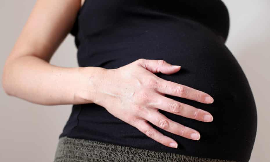 pregnant woman, bump only with her hand on it