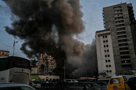 इजरायली मिसाइल से गिरी इमारत पर धुएं का बड़ा बादल छा गया।