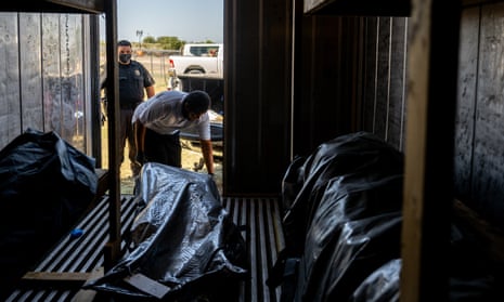 Deputy Sergeant Aaron Horta and Memorial Funeral Chapel Polo Vargas load a deceased body into a storage freezer on June 28, 2023 in Eagle Pass, Texas. According to local authorities, there has been an uptick in casualties and migrant crossings into the U.S. over the last two weeks. Maverick County Law Enforcement and paramedics are responding to larger volumes of medical related calls as temperatures soar across the region.
