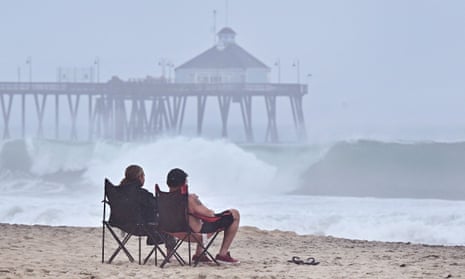 A couple views the increasingly large waves hitting Imperial Beach in southern California.