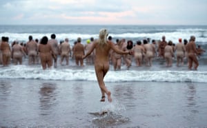 Participants in the annual north-east skinny dip run into the sea in Northumberland