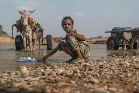 A girl collects water with a bottle