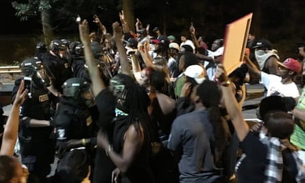 Protestors demonstrate in front of police officers wearing riot gear after police fatally shot Keith Lamont Scott in the parking lot of an apartment complex in Charlotte, North Carolina.