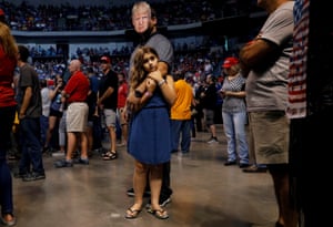 Thomas Musolino wears a mask of Donald Trump while holding his daughter Gianna Musolino during a Trump campaign rally at the Mohegan Sun arena.