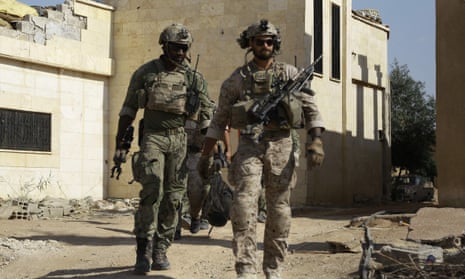 Armed men in uniform identified by Syrian Democratic forces as US special operations forces walk in the village of Fatisah in the northern Syrian province of Raqqa on Thursday.