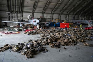 An Afghan air force A-29 attack aircraft is photographed with armoured vests lying on the ground inside a hangar at the airport.