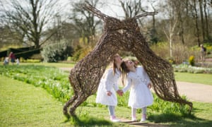 Children look at willow hare sculptures in Spring at RHS Garden Harlow Carr.