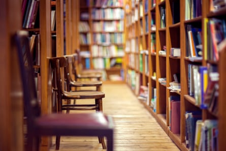 Library with books on shelf and empty chairsLibrary with rows of books on shelves and empty chairs