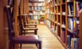 Library with rows of books on shelves and empty chairs