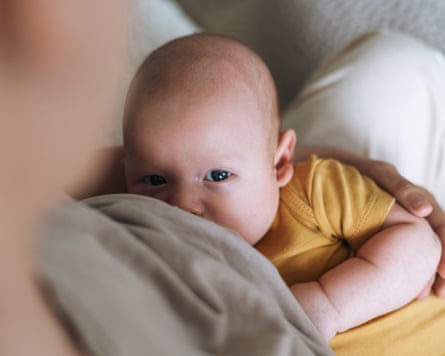 Young mother breastfeeding 2-3 month baby boy at home