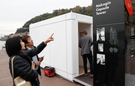 Tourists in Spain look at a real-size copy of one of the capsules of Tokyo’s Nakagin Tower