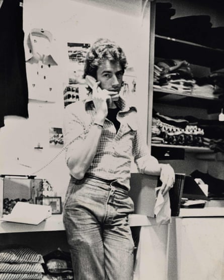 Paul Smith is shown in a black and white shot speaking on a telephone in his shop surrounded by clothes.
