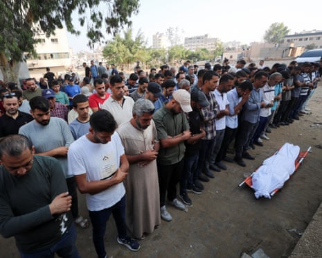 Mourners pray near the body of a Palestinian during a funeral at al-Shifa hospital in Gaza, July 23, 2025.