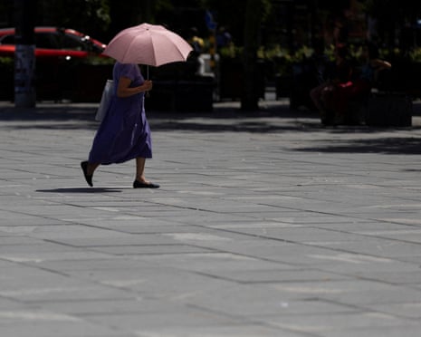 A woman uses umbrella to hide from the sun during heatwave in Belgrade, Serbia.