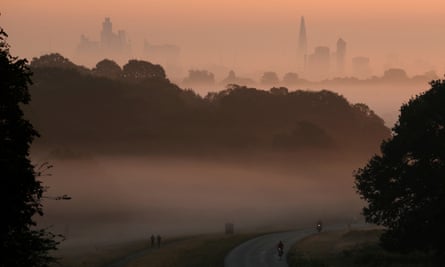 A misty morning with London’s skyline in the background and cyclists in the foreground