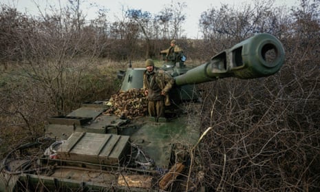 Ukrainian artillerymen standing atop their howitzer in a field near an undisclosed frontline position in eastern Ukraine.