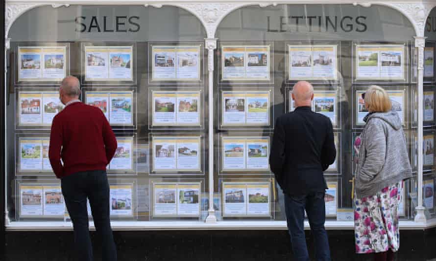 Signes de prix de maison affichés dans la fenêtre d'un agent immobilier
