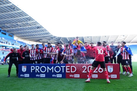 Lincoln City players celebrate promotion to the Sky Bet Championship.