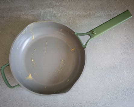 Our Place Los Angeles ceramic pan aerial view with a smudge of butter left in the pan. The pan is light grey with a sage green handle.