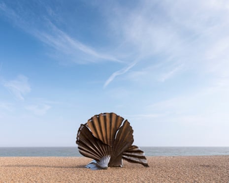 Sculpture of a scallop on a beach.