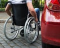 Close-up of a man sitting on a wheelchair near a car