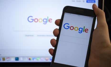 A Google logo on a phone screen and laptop.