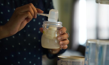 Woman preparing a formula feed for a baby