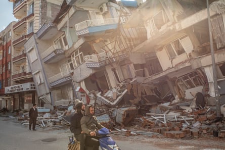 Residents of Samandağ pass by the ruins of their town.