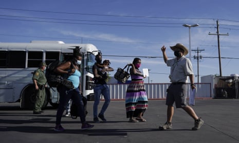 A member with the Border Humanitarian Coalition guides people as they are released from Border Patrol custody upon crossing the border in search of asylum Wednesday.